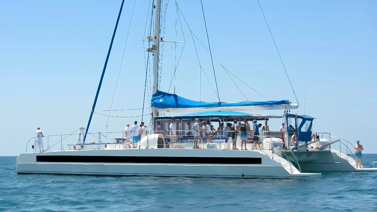 Catamarán Big Space navegando frente a Barcelona con pasajeros en cubierta