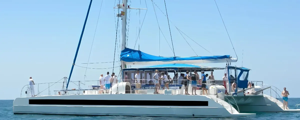 Catamarán Big Space navegando frente a Barcelona con pasajeros en cubierta