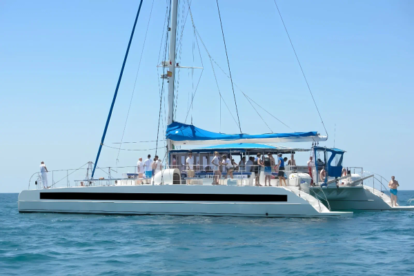Catamarán Big Space navegando frente a Barcelona con pasajeros en cubierta