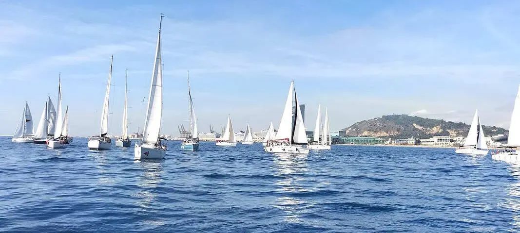 Veleros compitiendo en una regata corporativa frente a la costa de Barcelona en otoño