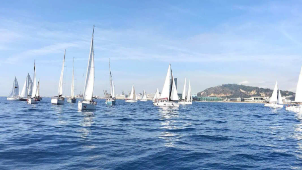 Veleros compitiendo en una regata corporativa frente a la costa de Barcelona en otoño
