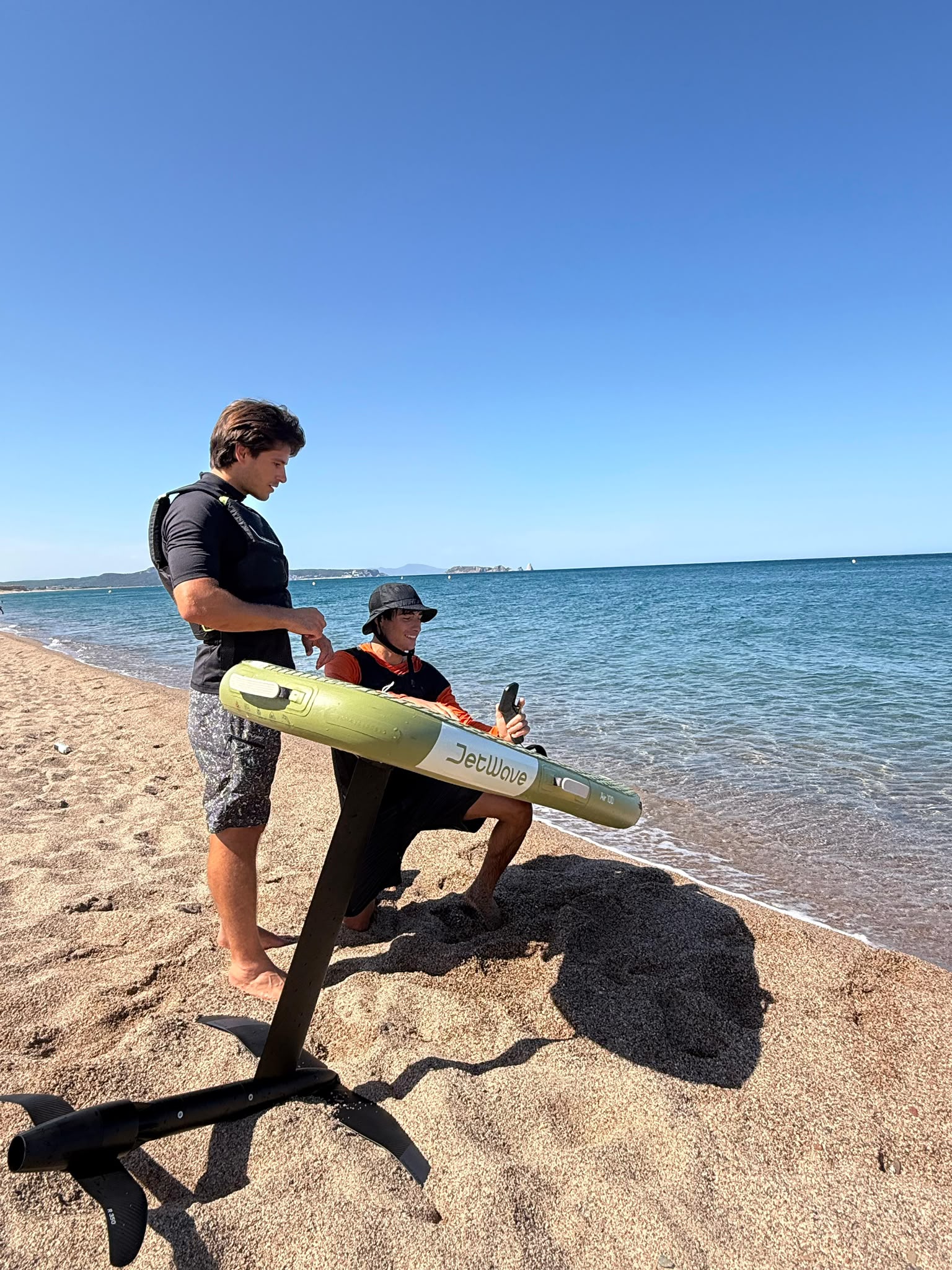 Sesión de e-foil en la Costa Brava – foil eléctrico deslizándose sobre aguas turquesas de una cala