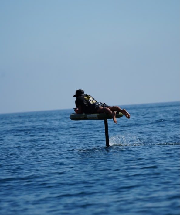 E-foil Costa Brava — instructor y alumno en cala de aguas turquesas