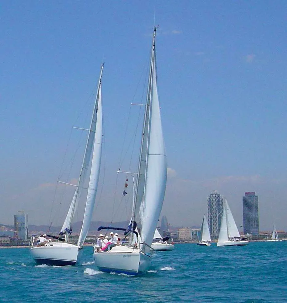 Veleros ciñendo con el skyline de Barcelona al fondo