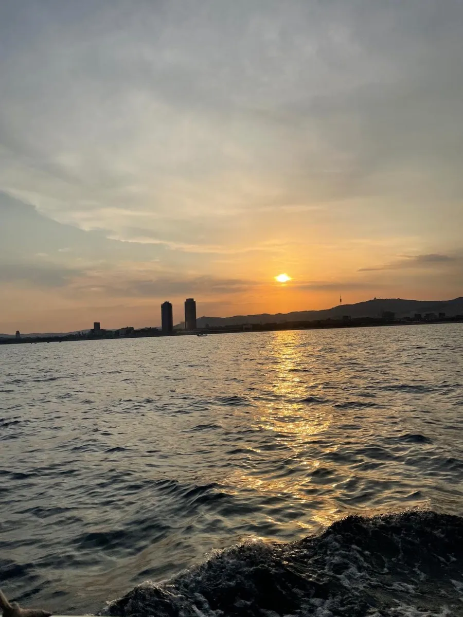 Las torres del Port Olímpic y la costa de Barcelona al atardecer desde el barco. Foto de Daniel M., reseña de Google
